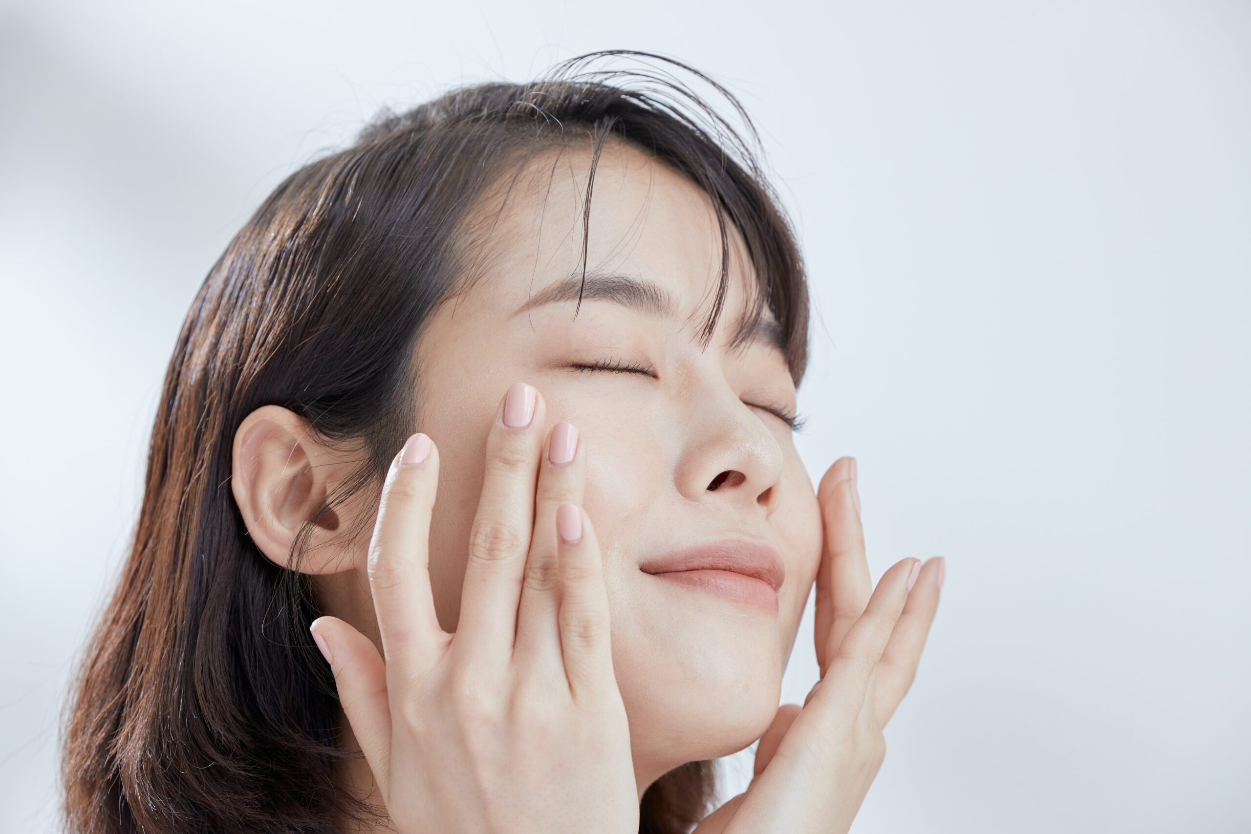 A young woman cleansing her face